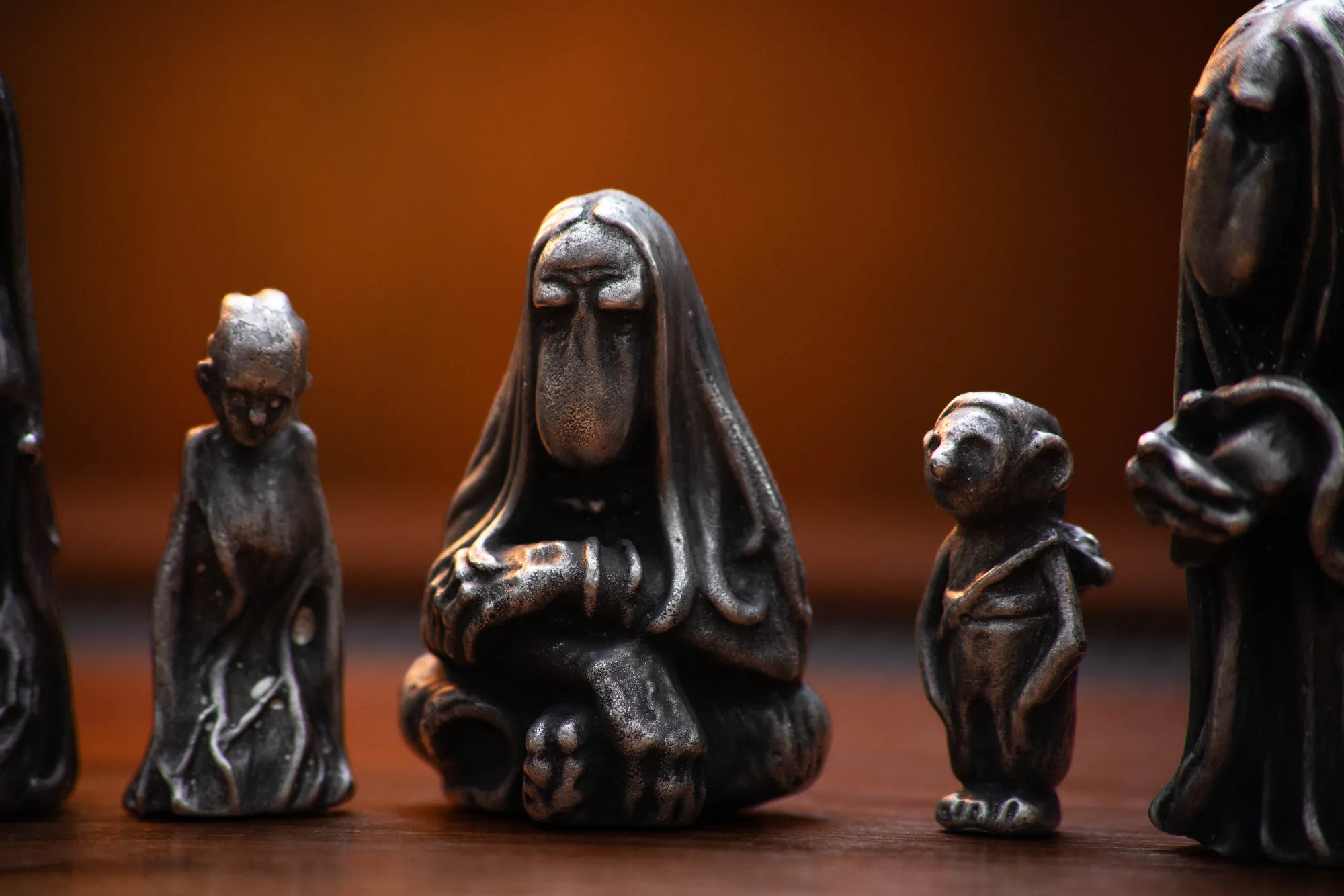 Dark pewter Dusk charms gathered on a wooden table