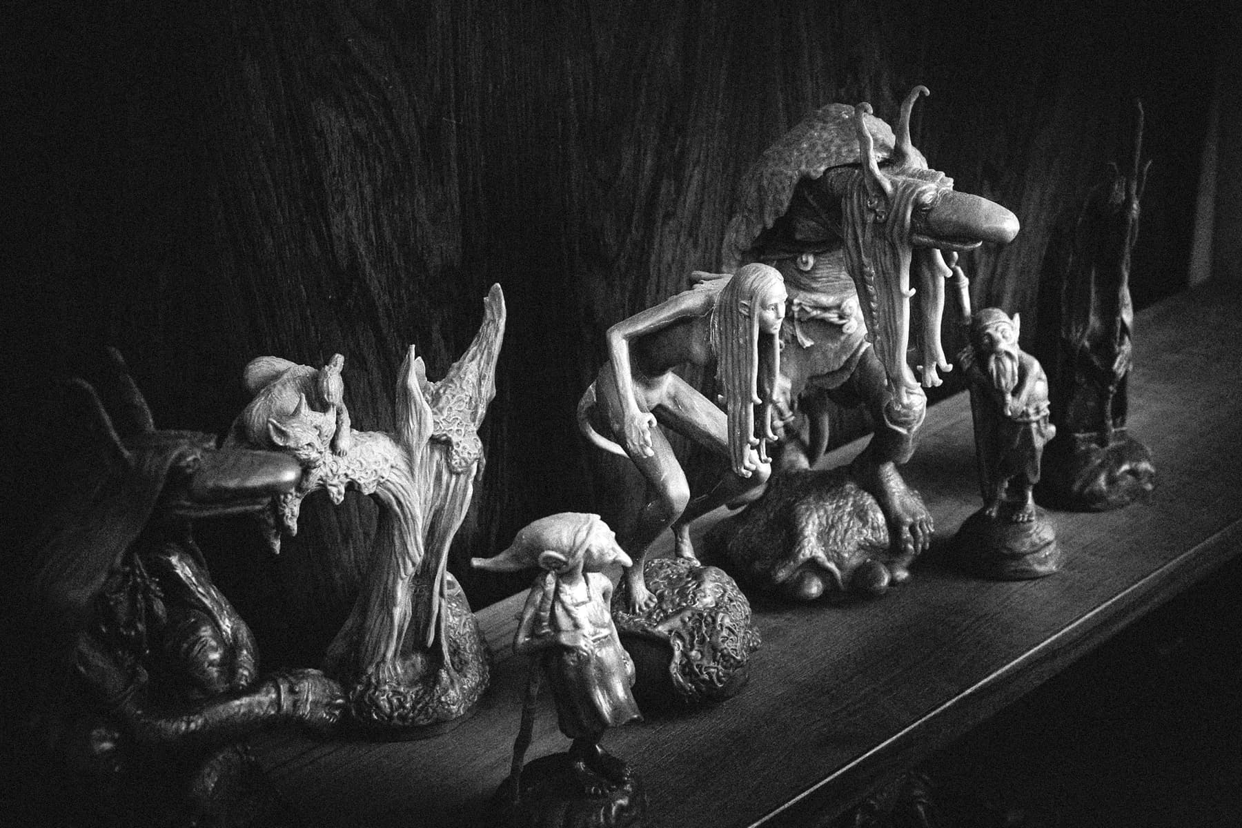 Trollheim scale statues arranged on a wooden shelf